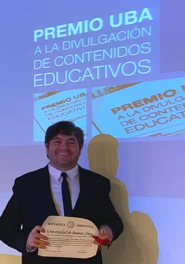 Jorge Cabrera sostiene el diploma del Premio UBA a la divulgación de contenidos educativos.